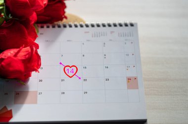 Sevgililer Günü Konsepti. 14 Şubat 'ta, takvim bir aşk gününü işaret ediyor, kırmızı kalpler boşlukları süslerken, Sevgililer Günü' nü simgeliyor, romantizm ve şefkat dolu bir kutlama..