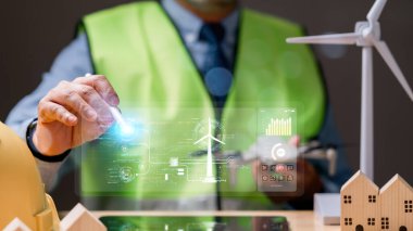 Mühendis adam, rüzgar ve güneş enerjisini güneş pilleri vasıtasıyla kullanan, temiz enerji üretimine aktif olarak katkıda bulunan ve küresel ısınmayı azaltan bir yel değirmeninin bakımını yapıyor..