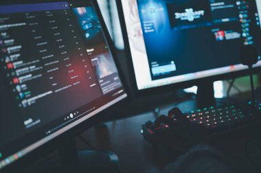 Bilgisayar oyunu konsepti. Siber uzaya dalan oyuncu, dijital alemde hassas bir şekilde geziniyor, bir masaüstü, klavye ve monitör kullanarak çevrimiçi oyunlar oynuyor ve teknoloji dünyasını kucaklıyor..