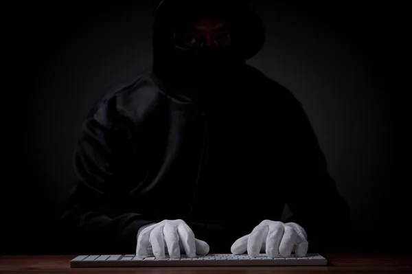Hacker, security concept. Hacker, typing intricate code on a laptop, establishes an online connection, aiming to breach server security, hack passwords, and gain unauthorized access to the database