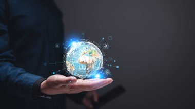 Bir iş adamı elinde mavi gömlekli ve siyah bileklikli bir küre tutuyor. Küre, çizgiler ve noktalardan oluşan bir ağ ile çevrilidir.
