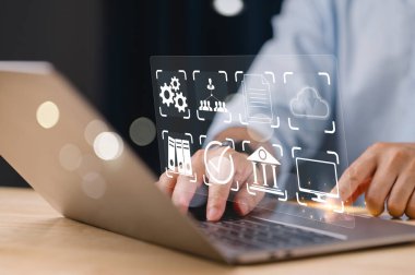 Bir kişi bir sürü simgesi ve işaretli ekranı olan bir dizüstü bilgisayar kullanıyor. Kişi, ekrandaki çeşitli simgeleri kullanmasını gerektiren bir proje veya görev üzerinde çalışıyor olabilir.