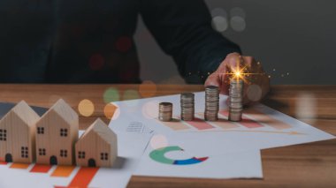 Bu resim gayrimenkuldeki finansal büyüme sürecini gösteriyor, yükselen bir tabloya doğru para istiflemek, yatırım başarısını ve gayrimenkul değerini simgeliyor.