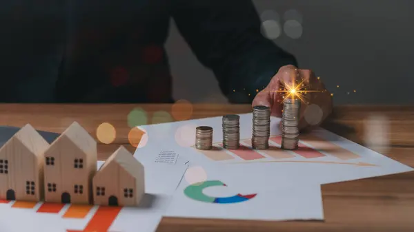 Bu resim gayrimenkuldeki finansal büyüme sürecini gösteriyor, yükselen bir tabloya doğru para istiflemek, yatırım başarısını ve gayrimenkul değerini simgeliyor.