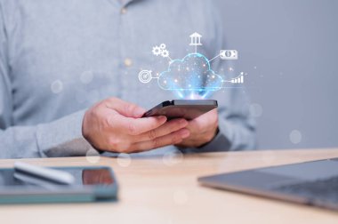 İnsan akıllı telefonla etkileşime girer, bulut teknolojisi kavramlarını görselleştirir, finans, analitik ve iletişim görüntülerinin entegrasyonunu vurgular, dijital dönüşümün özünü yakalar