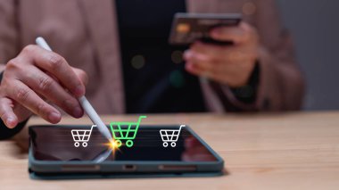 İnsanlar tablet konseptini kullanarak online alışveriş yapıyor. Kullanıcı tabletle uğraşırken çevrimiçi alışverişin kolaylığını keşfetmek, güvenli işlemler için kredi kartı tutarken stilus 'u ürünleri keşfetmek için kullanmak