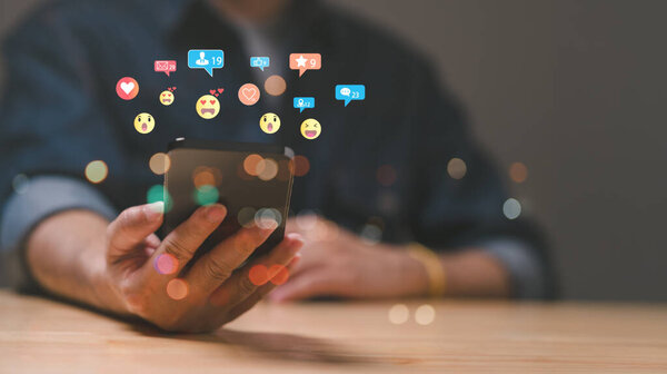 Влиятели, человек взаимодействует со своим смартфоном, окруженный яркими уведомлениями и реакциями в социальных сетях, иллюстрируя динамичный и эмоциональный ландшафт цифровой коммуникации