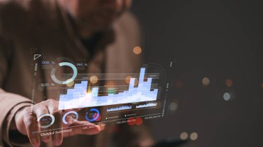 Bir işadamı üzerinde grafik olan bir ekranı işaret ediyor. Grafikte düşüş eğilimi var, bu da satışlarda ya da olumsuz sonuçlarda düşüş olabilir. Adamın parmağı grafiğin üzerinde geziniyor.