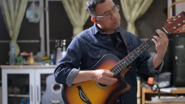 Kanepede gitar çalan adam.