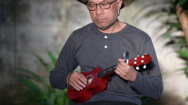 Gitar çalan Asyalı son sınıf öğrencisinin portresi