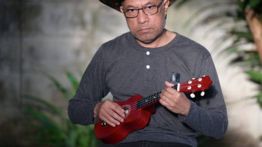 Gitarlı ve akustik gitarlı yakışıklı Asyalı adamın portresi. müzik konsepti.