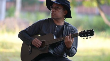 Adam parkta bir gitar ile