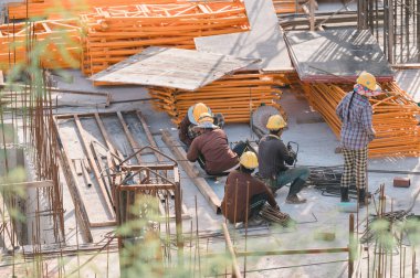 İnşaat işçileri, inşaat işçileri grubu inşaat sahasına özenle malzeme döşedi, inşaat sektöründe takım çalışması