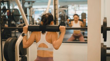 Kadın Spor Salonu Spor Salonu Motivasyonunu Güçlendiren Bu Kadın Mükemmel Şekilde Çömeliyor, Beyaz Spor Sütyen Giyiyor, Spor Salonu Kurulumu, Ağırlık Tabakları, ve Destekleyici Sırt,