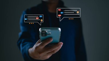 Adam sanal sosyal medya bildirim simgeleriyle çevrimiçi geri bildirim içeren akıllı telefonu tutuyor. Konsept müşteri deneyimi, memnuniyet anketi, dijital pazarlama, iletişim, teknoloji sektörü.