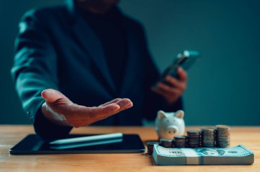 İşadamı para, para ve kumbarayla birlikte masayı devretmeyi teklif ediyor. Yatırım tavsiyesi, tasarruf büyümesi, refah yönetimi, krediler, bankacılık, ekonomik desteği temsil eden mali konsept,
