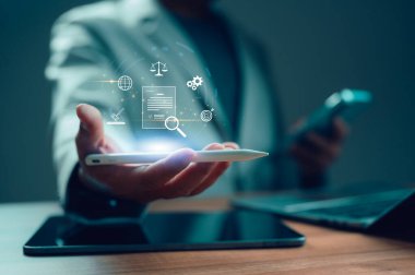 Profesyonel iş adamı elinde Stylus 'un dijital arayüzü var. Simgeler hukuki uyum, küresel ağ, veri analizi, stratejik planlama ve işlem yönetimini temsil ediyor. Resimleri kavramlandır