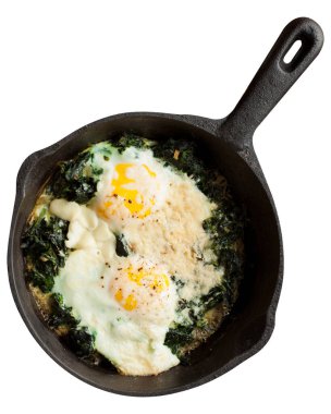 Sağlıklı kahvaltı, tavada ıspanaklı sahanda yumurta, beyaz arka planda izole edilmiş..