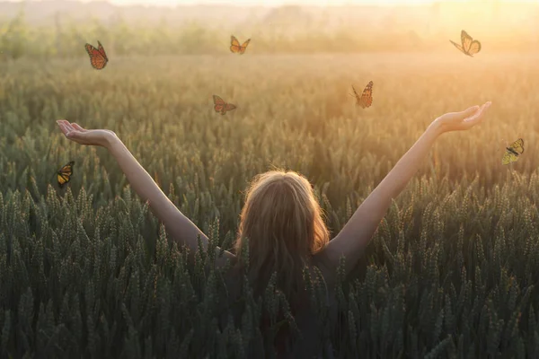 一个女人和自由的蝴蝶在自然界中飞行时的超现实相遇 — 图库照片