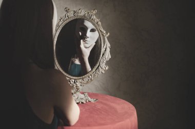 Aynanın önünde maske takan kibirli bir kadının yansıması, kimlik konsepti.