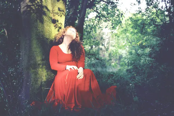Pani Czerwonej Sukience Zasypia Anielsko Opierając Się Drzewo Lesie — Zdjęcie stockowe