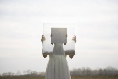 Yüzünün önünde kendini bir döngü içinde resmeden gerçek üstü bir kadın; soyut bir kavram.