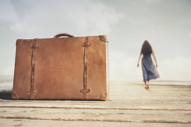 Bir gezginin köprüsünde dinlenen bavul yeni dünyalar keşfetmek için yürüyor, seyahat kavramı.
