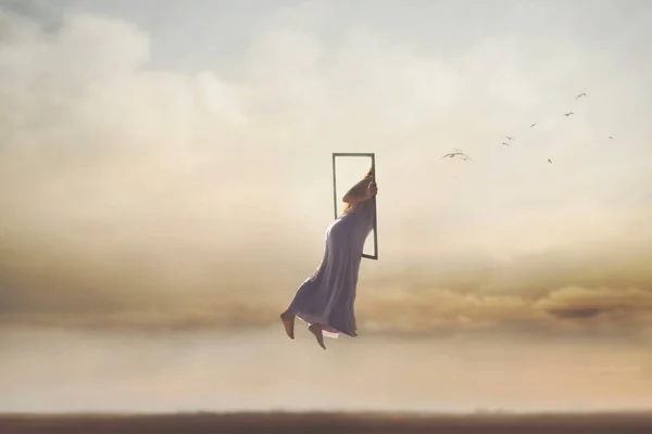 Stock image surreal and magical journey of a woman who disappears from the real world through a frame, merging into the sky, abstract concept