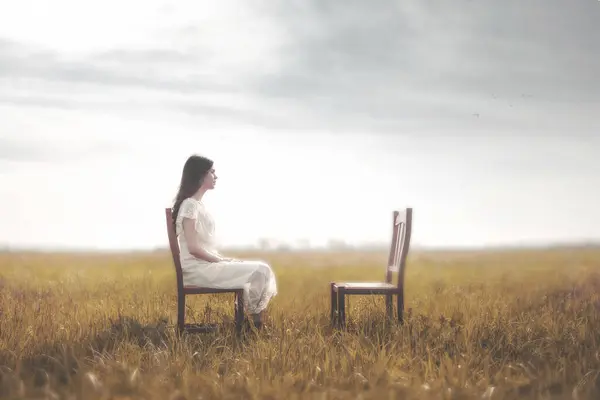 Smutna Kobieta Siedząca Przed Pustym Krzesłem Kochanka Koncepcja Samotności Zdjęcia Stockowe bez tantiem