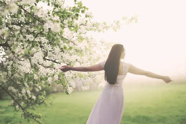 Junge Weiß Gekleidete Frau Atmet Inmitten Der Frühlingshaften Natur Stockfoto