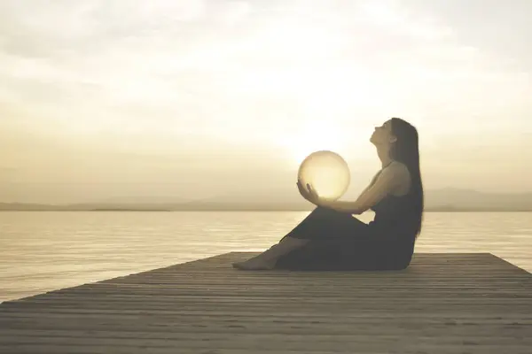 Mujer Protegiendo Una Esfera Mágica Iluminada Por Sol Que Libera Imagen de stock