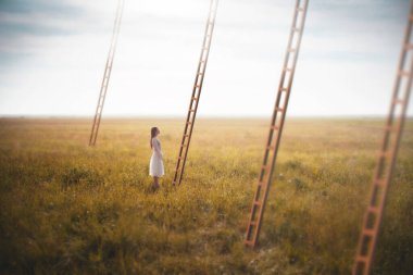 Kadın gökyüzünden inen gerçeküstü bir merdiven seçiyor, iş konsepti.