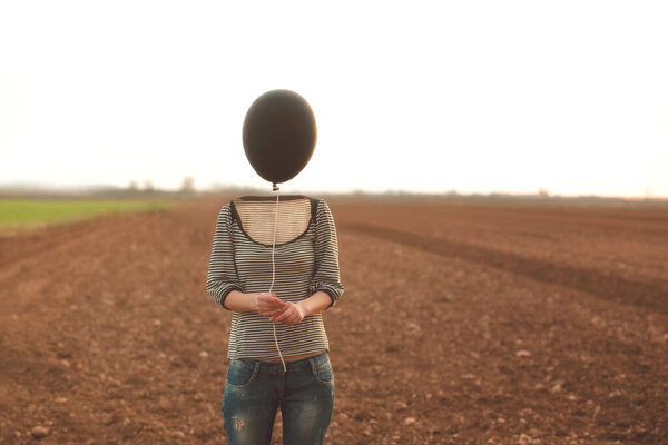 woman's head replaced by a black balloon