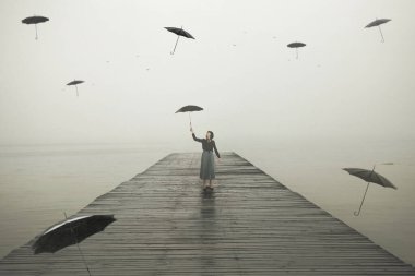 Uçan şemsiyelerle çevrili iskelede yürüyen şemsiyeli kadın, soyut bir kavram.