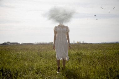 Çayırda yüzü yerine bulutlu bir kadın