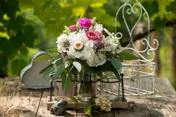 庭の木製テーブルの上にバラと夏の花の花束 — ストック写真