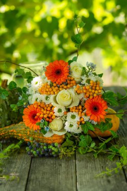 Renkli çiçek buketi ve bahçe masasında güller.