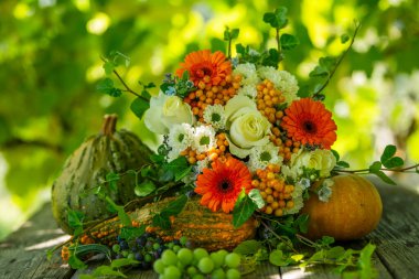 Renkli çiçek buketi ve bahçe masasında güller.