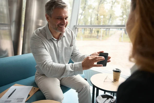 남자는 전화로 동료에게 비디오를 사무실 시간에 커피를 마시며 대화를 나눈다 — 스톡 사진
