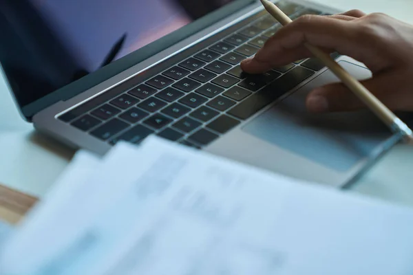 職場でノートパソコンのキーボードを入力するプロセス 鉛筆で手を背景に — ストック写真