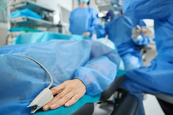 Hastanenin Ameliyathanesinde Mavi Koruyucu Takım Elbiseli Bir Hasta Yatıyor — Stok fotoğraf