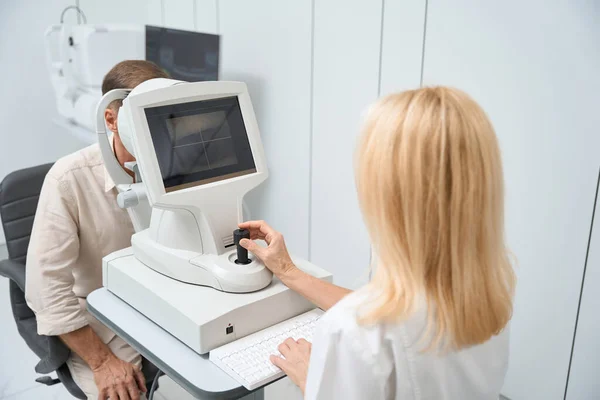 코트를 간호사가자 프랙탈 미터에 캐비닛에 쌍안경으로 검사를 — 스톡 사진