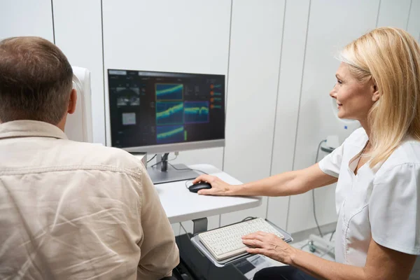 Bilgisayarın Başında Oturan Beyaz Önlüklü Bir Tıp Çalışanı Hastaya Göz — Stok fotoğraf