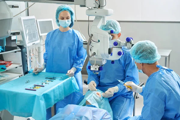 Orvosokból Álló Csapat Akik Kanapén Fekvő Mellett Állnak Szemműtétre Készülnek — Stock Fotó