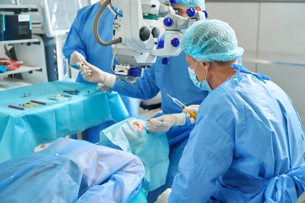 Sebészekből Álló Csapat Akik Beteg Mellett Állnak Kanapén Fekszenek Szemműtétre — Stock Fotó