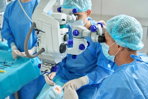 Doktorlardan Oluşan Bir Ekip Kanepeye Uzanmış Göz Ameliyatı Yapıyor Cerrahi — Stok fotoğraf
