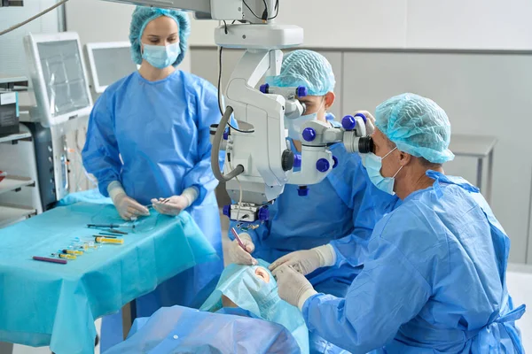 Equipe Médicos Perto Cliente Deitado Sofá Fazendo Uma Operação Ocular — Fotografia de Stock