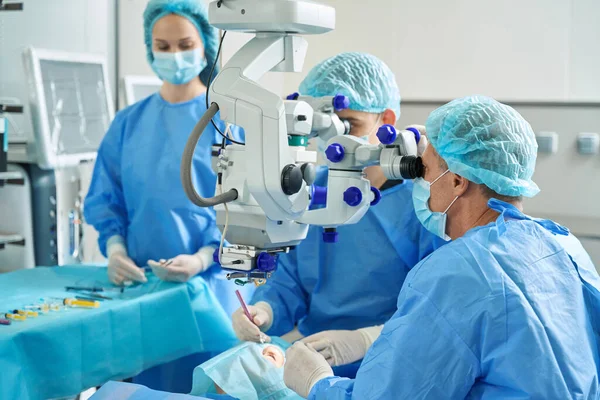 Bir Grup Cerrah Müşterinin Yanında Duruyor Kanepede Uzanıp Göz Ameliyatı — Stok fotoğraf