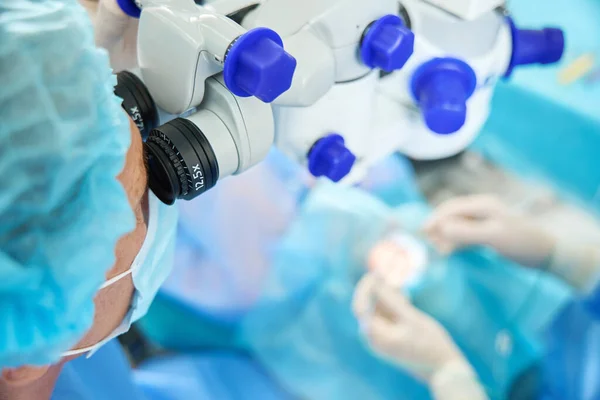 Médico Proteção Máscara Chapéu Olhando Microscópio Cirúrgico Olhando Através Dele — Fotografia de Stock