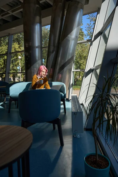 Νεαρή Γυναίκα Ροζ Μαλλιά Κάθεται Στον Καναπέ Συνεργασία Κοντά Στο — Φωτογραφία Αρχείου